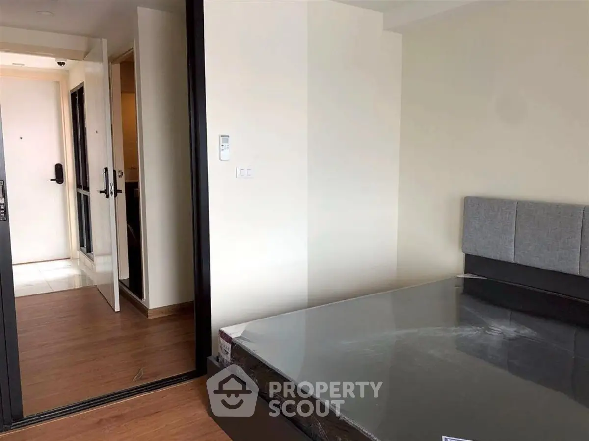 Modern bedroom with sleek design and wooden flooring in a contemporary apartment.