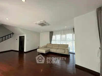 Spacious living room with modern sofa and wooden flooring