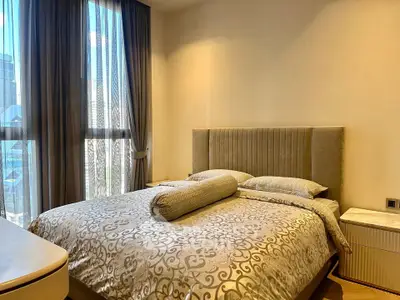 Luxurious bedroom with elegant decor and large window offering city views