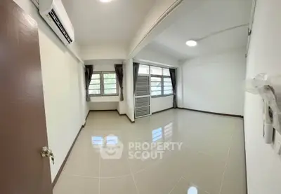 Spacious unfurnished room with large windows and air conditioning, perfect for customization.