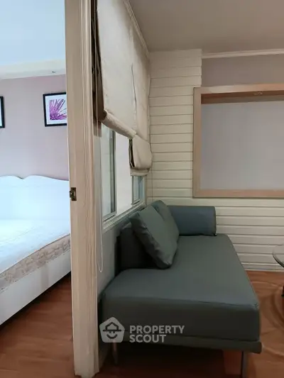 Cozy interior with a stylish sofa and a glimpse of a bedroom, perfect for modern living.
