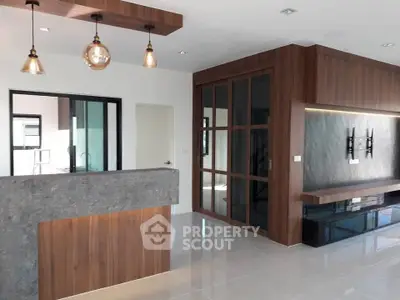 Modern living room with stylish wood paneling and sleek lighting fixtures.