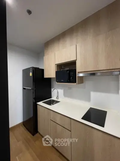 Modern kitchen with sleek cabinetry and appliances in a compact layout.