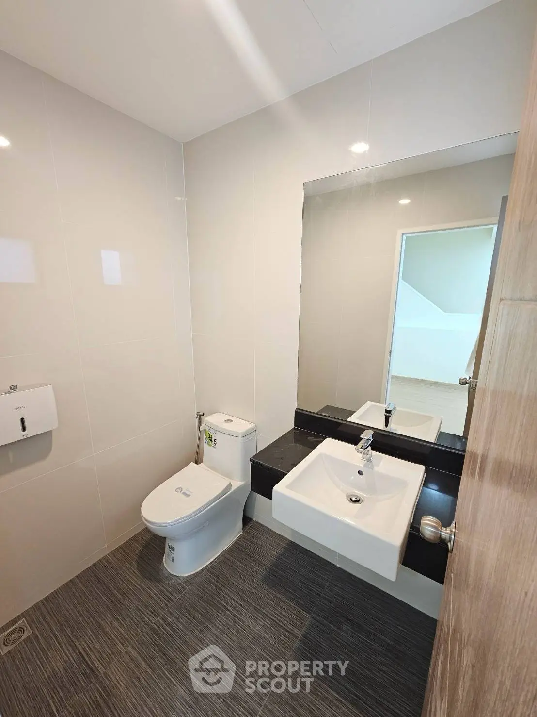 Modern bathroom with sleek fixtures and minimalist design, featuring a wall-mounted sink and toilet.