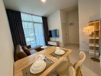 Modern living room with dining area, stylish furniture, and natural light.