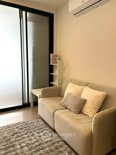 Cozy living room with modern sofa and air conditioning, perfect for relaxation.