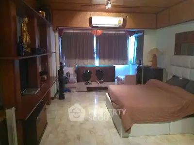 Spacious bedroom with elegant decor and marble flooring in luxury apartment