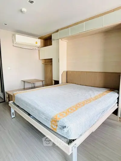 Modern bedroom with built-in storage and air conditioning in a stylish apartment.