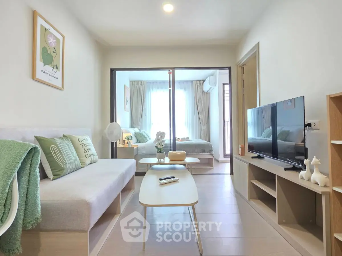 Modern living room with cozy decor and view into a stylish bedroom, perfect for urban living.