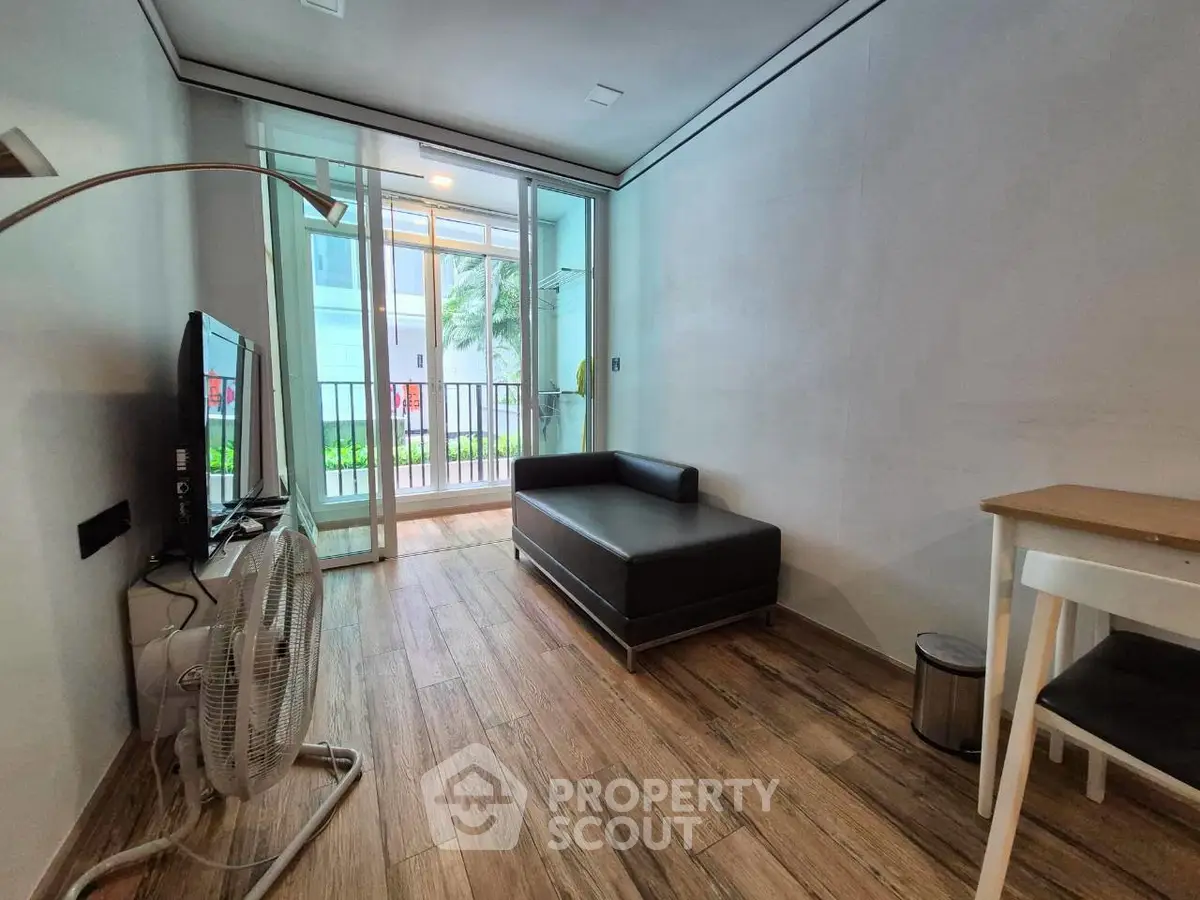 Modern living room with sleek design and garden view, featuring a cozy sofa and wooden flooring.