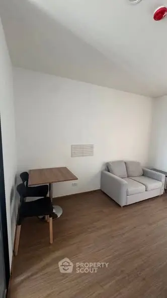 Cozy living room with modern furniture and wooden flooring, perfect for relaxation.