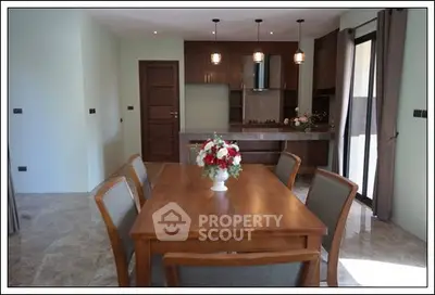 Elegant dining area with wooden table and modern kitchen in open layout