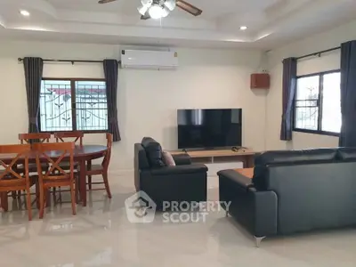 Spacious living room with modern furniture and large TV, perfect for relaxation and entertainment.