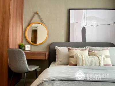 Cozy modern bedroom with stylish wall art, elegant bedding, and a charming round mirror adding a touch of sophistication to the space.