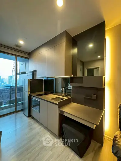 Modern kitchen with sleek cabinetry and open layout in high-rise apartment with city view.