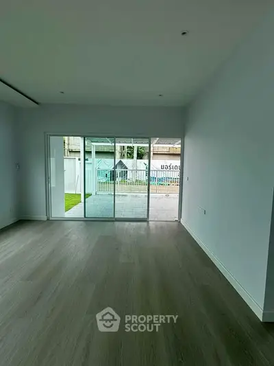 Spacious living room with sliding glass doors leading to a patio and garden area, perfect for indoor-outdoor living.