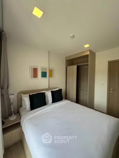 Modern bedroom with stylish decor and ample natural light, featuring a cozy bed and sleek wardrobe.