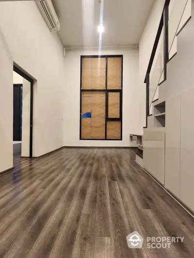 Spacious modern living room with wooden flooring and staircase