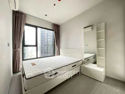 Modern minimalist bedroom with large window and sleek furnishings.