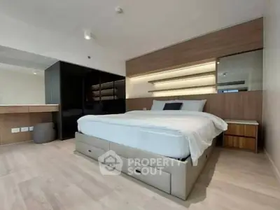 Modern bedroom with sleek design, featuring built-in storage and stylish lighting.