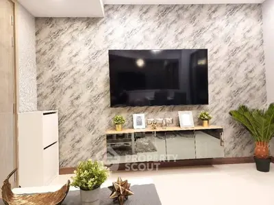 Modern living room with stylish decor and large wall-mounted TV