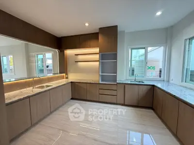 Spacious modern kitchen with sleek wooden cabinetry and ample natural light.