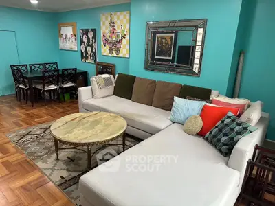 Spacious living room with stylish decor and vibrant wall art, featuring a large sectional sofa and elegant dining area.
