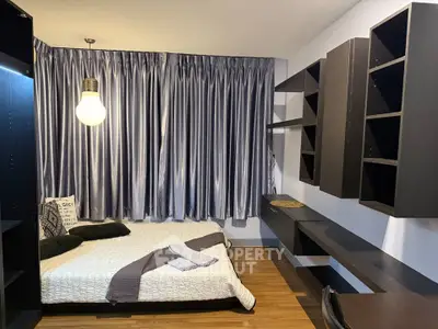 Modern bedroom with sleek shelving and cozy bed, featuring elegant curtains and warm lighting.