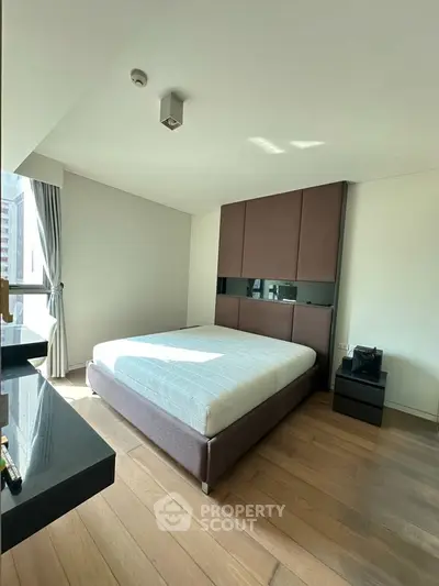 Spacious bedroom with modern design and large window offering natural light