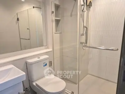 Modern bathroom with glass shower and sleek fixtures in a contemporary apartment.
