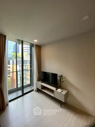 Modern living room with large windows and city view, featuring sleek TV stand and minimalist decor.