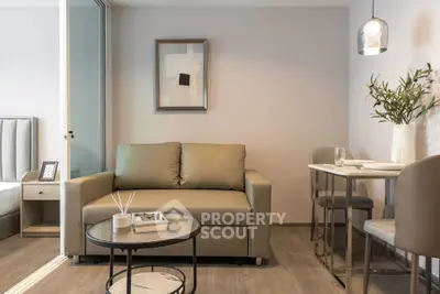 Modern living room with stylish decor and open layout, featuring a cozy sofa and dining area.