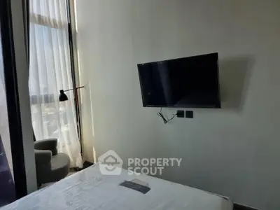 Modern bedroom with wall-mounted TV and floor-to-ceiling window.