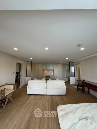 Spacious modern living room with elegant furniture and open kitchen layout, perfect for stylish urban living.