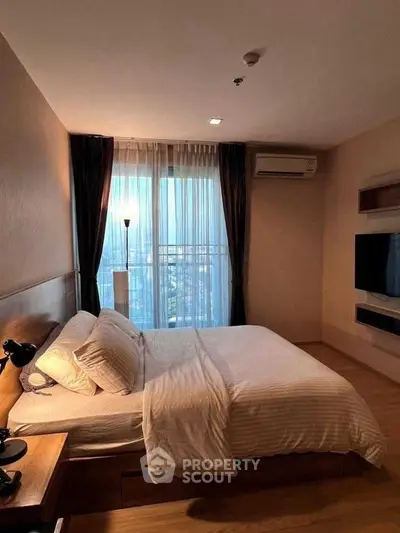 Cozy bedroom with city view, modern furnishings, and natural light.