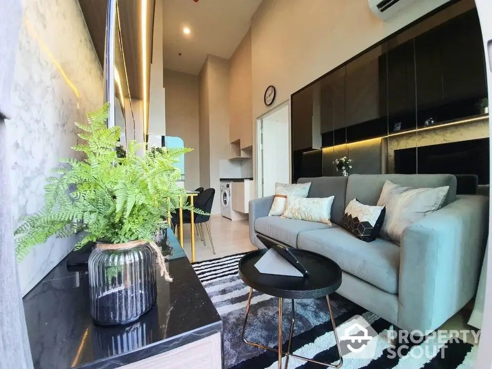 Modern living room with stylish decor and open layout, featuring a cozy sofa and elegant furnishings.