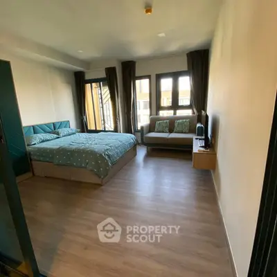 Spacious bedroom with modern decor and large windows for natural light.