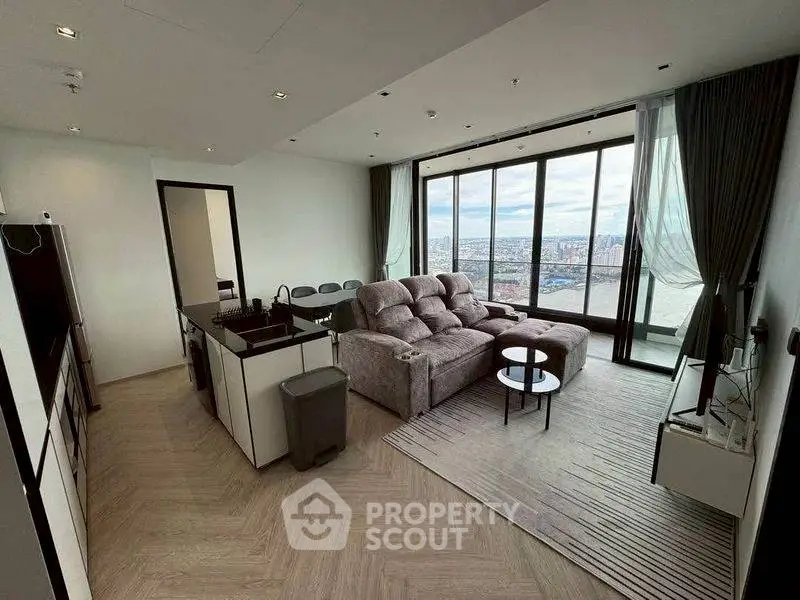 Spacious modern living room with panoramic city view and elegant furnishings.