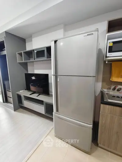 Modern apartment interior with sleek fridge and entertainment center