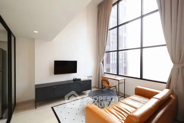 Modern living room with high ceilings and large windows in a stylish apartment.