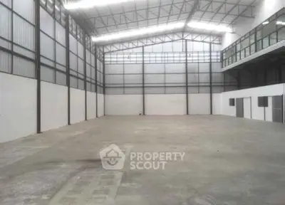 Spacious industrial warehouse with high ceilings and ample natural light.
