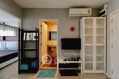Modern apartment interior with bedroom, bathroom, and living area featuring sleek furniture and air conditioning.