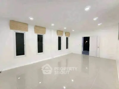 Spacious modern living room with tiled flooring and recessed lighting