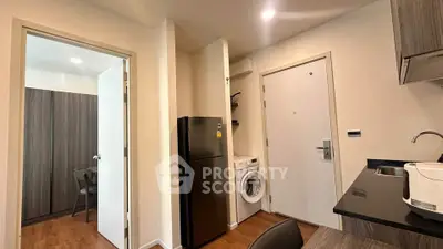 Modern apartment interior with kitchen and laundry area featuring sleek appliances.