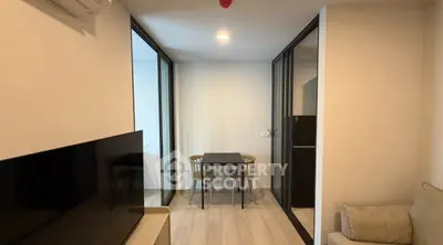 Modern apartment interior with cozy living area and dining space, featuring sleek design and natural lighting.