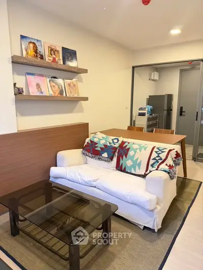 Charming living room with cozy sofa, stylish decor, and modern open kitchen in a contemporary apartment.