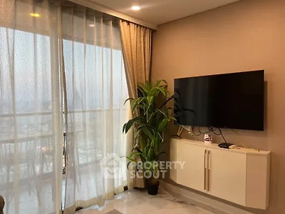 Modern living room with large TV and balcony view