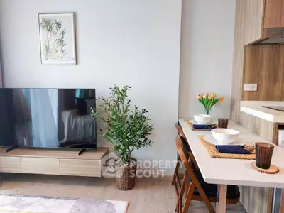 Modern living room with stylish decor and dining area, featuring a large TV and elegant furnishings.