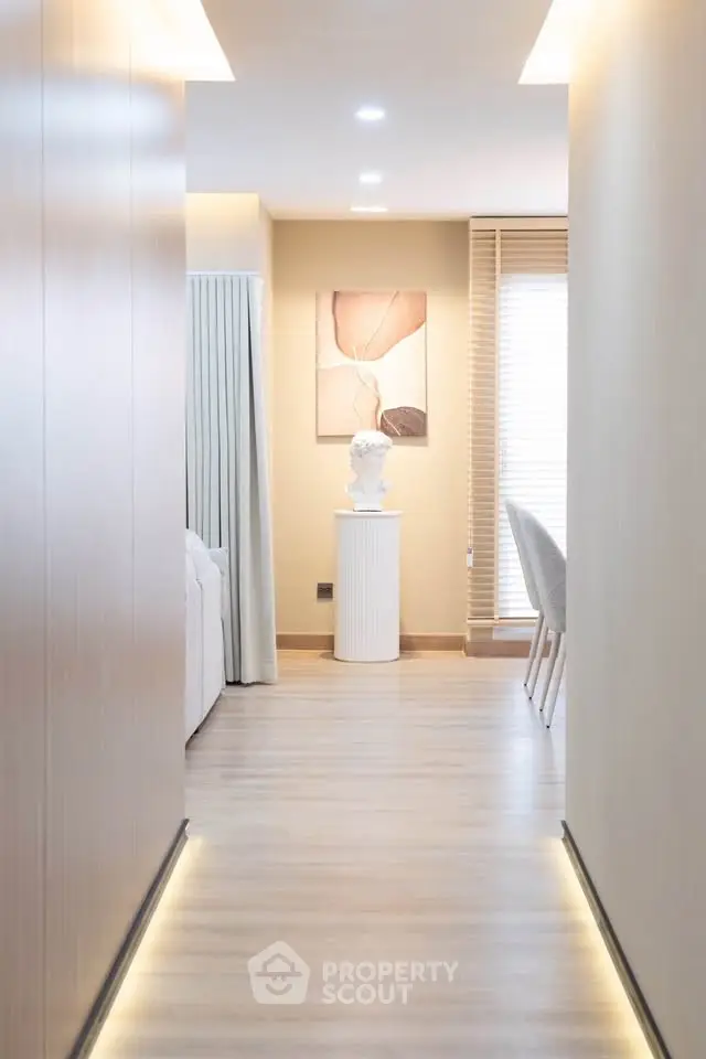 Modern hallway with elegant decor and soft lighting leading to a cozy living area.