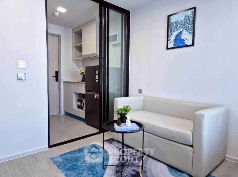 Modern living room with sleek design and compact kitchen area, perfect for urban living.